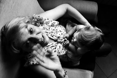 Portrait of mother with daughter sitting on sofa at home