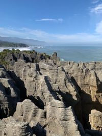 Scenic view of rocks in sea against sky