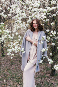 Beautiful girl in a dress walking in a blooming garden