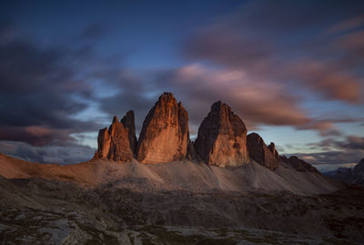 Scenic view of mountains against cloudy sky during sunset