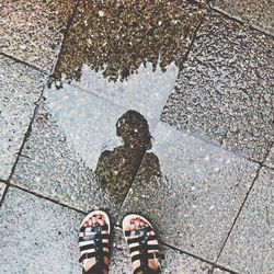 Low section of person standing in puddle