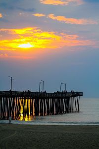 Pier over sea against sky during sunset