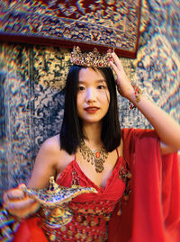 Portrait of young woman standing against trees