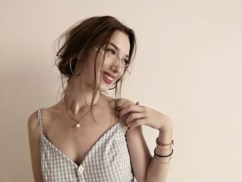 Portrait of smiling young woman against white background