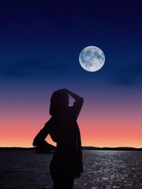 Rear view of silhouette woman standing against sea during sunset