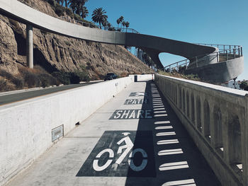 Road sign on bridge against sky