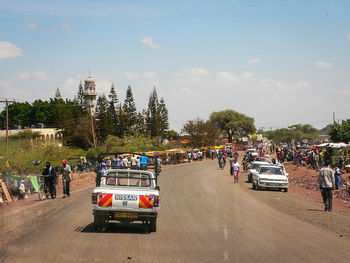 People on road against sky in city