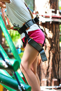 Midsection of girl on obstacle course in forest
