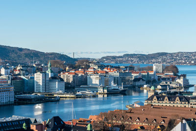 Aerial view of city by sea against clear sky