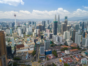 Petronas towers amidst cityscape against sky