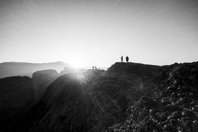 People standing on mountain road against sky