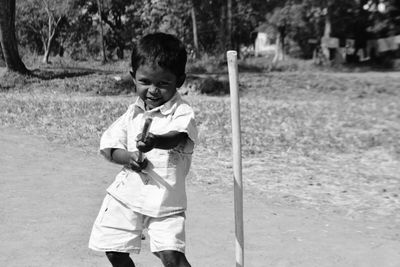 Portrait of young boy playing with stick