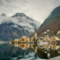 Scenic view of lake by buildings against sky