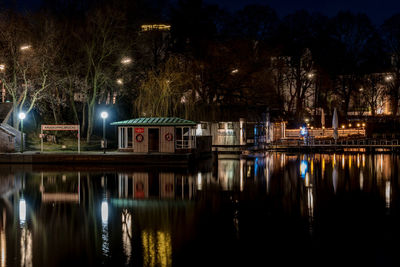 Reflection of trees in lake at night