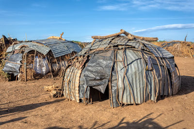 Panoramic view of hut on field against sky