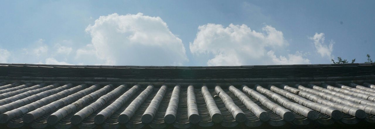 sky, low angle view, cloud - sky, cloud, built structure, building exterior, cloudy, architecture, day, blue, in a row, outdoors, pattern, roof, no people, white color, sunlight, nature, side by side, high section