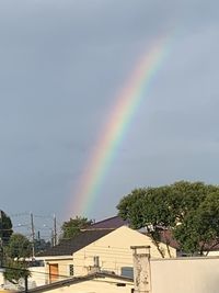 Rainbow over buildings against sky