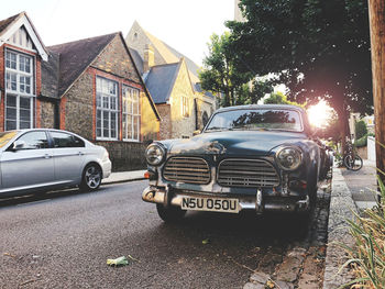 Cars parked on road amidst buildings in city