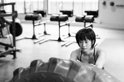 Young woman exercising with tire at home