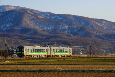 Train on field against mountain range