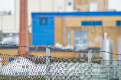 Chainlink fence against buildings in city