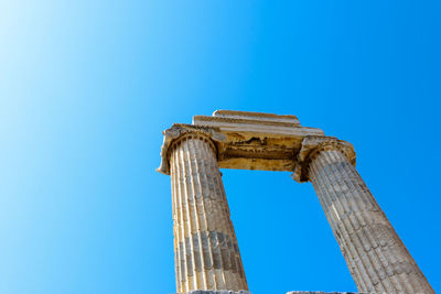 Low angle view of old ruin against blue sky