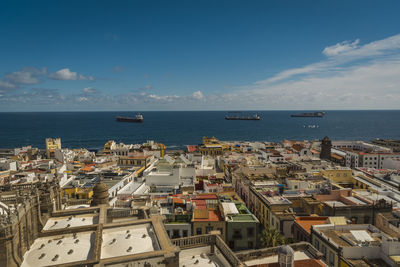 High angle view of town by sea against sky