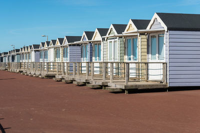 Buildings on beach against clear blue sky