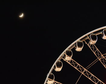 Low angle view of illuminated ferris wheel against sky at night