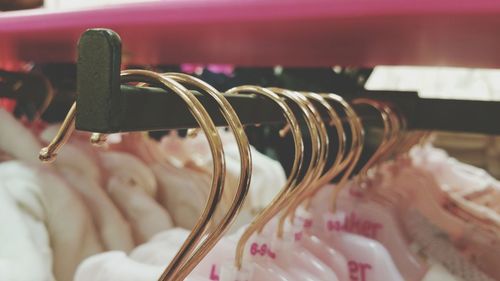 Close-up of coathangers hanging on rack at store