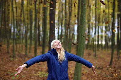 Portrait of young woman standing in forest