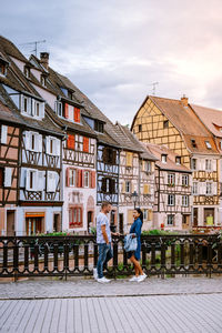 People on wall against buildings in city