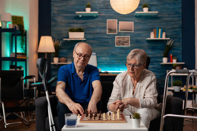 Senior couple playing chess at home