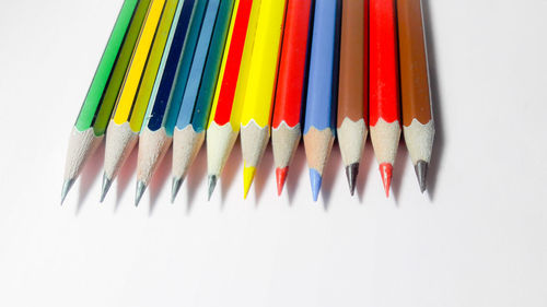 High angle view of colored pencils against white background