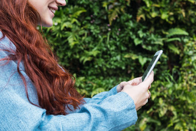 Closeup of hands of beautiful young business woman looking at her smart phone. empty space for text