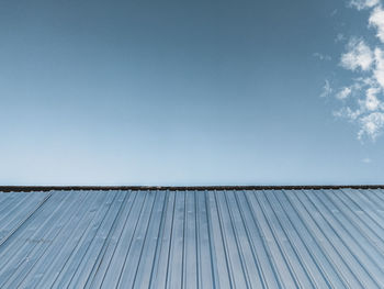 Low angle view of roof against blue sky