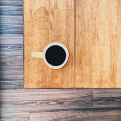 High angle view of coffee cup on wooden table