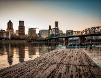 Bridge over river in city against clear sky