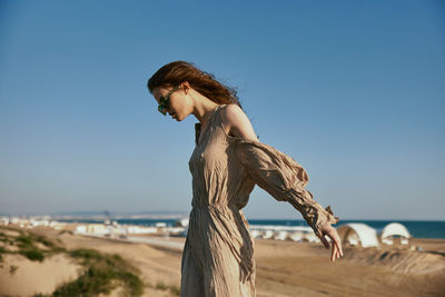 Portrait of young woman standing at beach