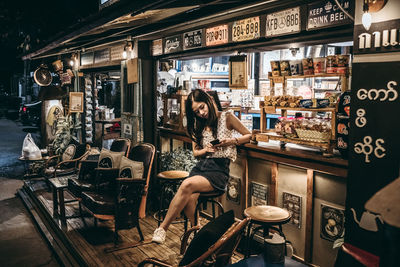 Woman sitting on table in store