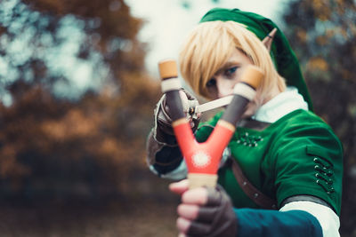 Person in elf costume aiming slingshot