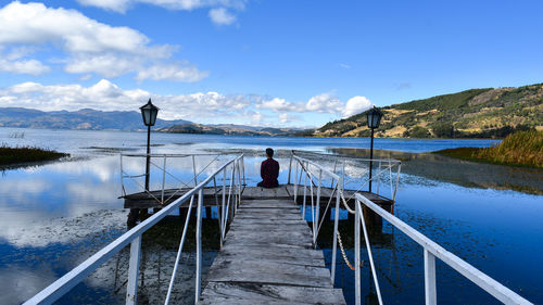 Rear view of man on lake against sky