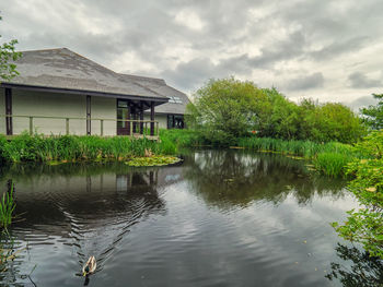 Building by lake against sky