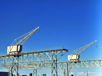 Low angle view of communications tower against clear blue sky