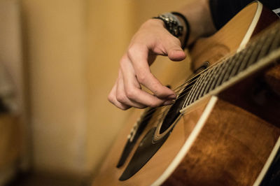 Midsection of man playing guitar