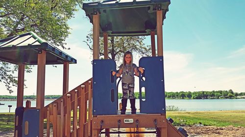 Full length of young woman on built structure against sky