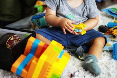 Rear view of a boy sitting with toy