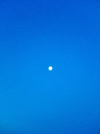 Low angle view of moon against blue sky