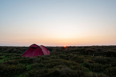 Tent on field against sky during sunset