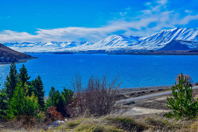 Scenic view of sea and mountains against blue sky